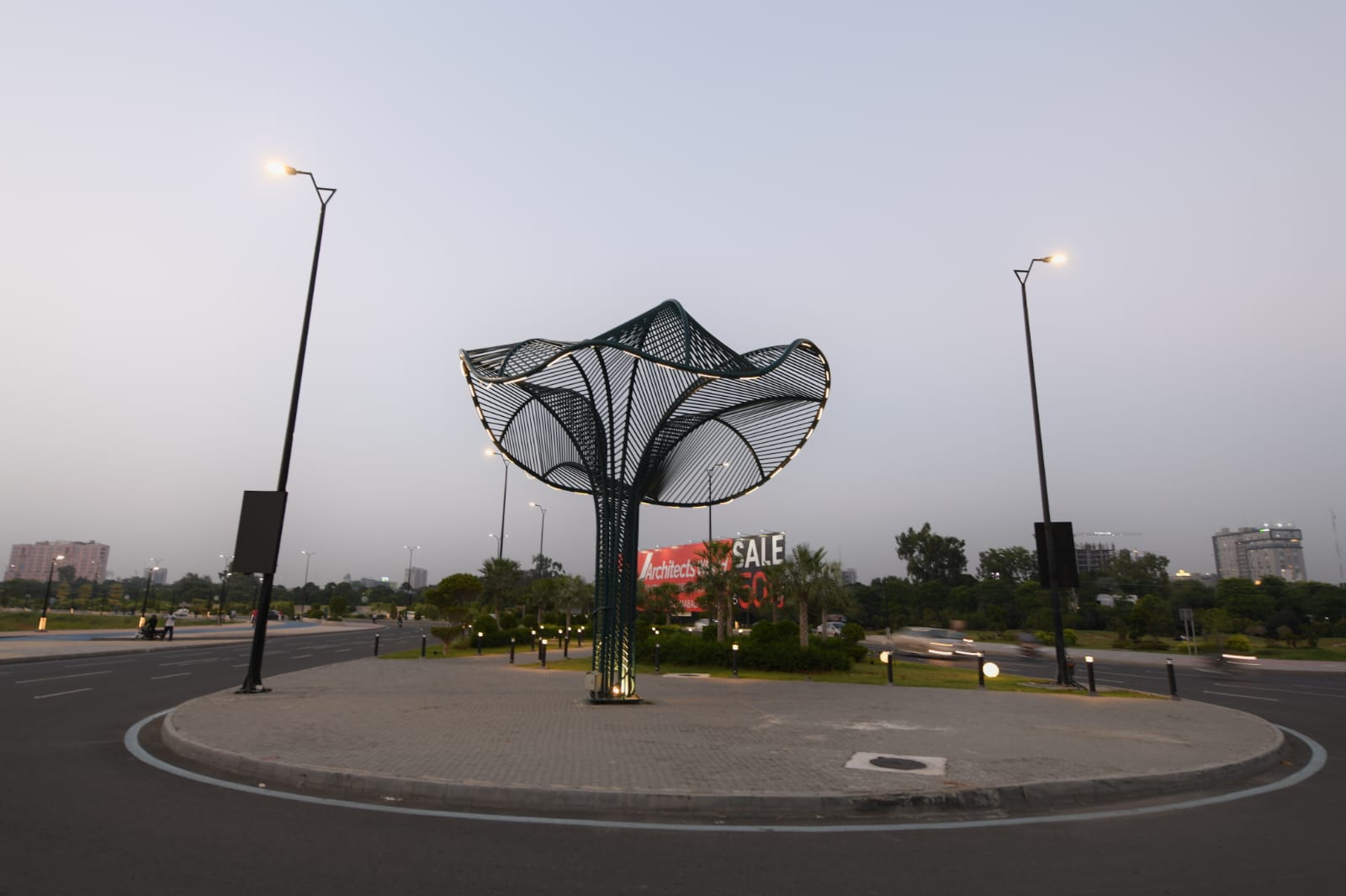 Tree-shaped canopy structure on CBD Route 47 roundabout in Lahore at dusk